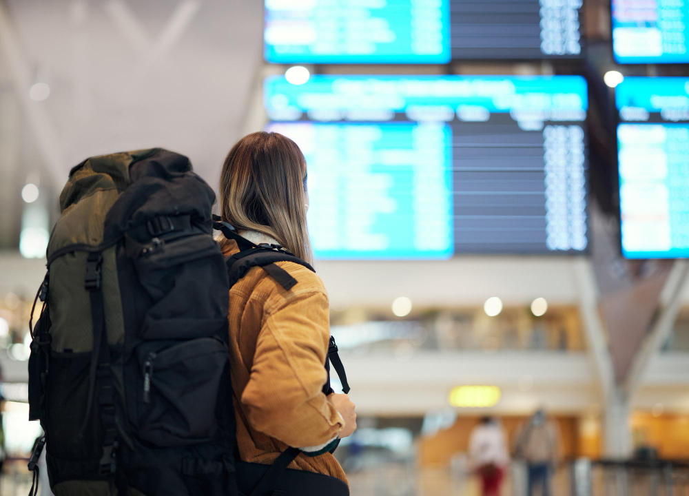 International traveler holding passport and boarding pass at airport departure gate before overseas flight