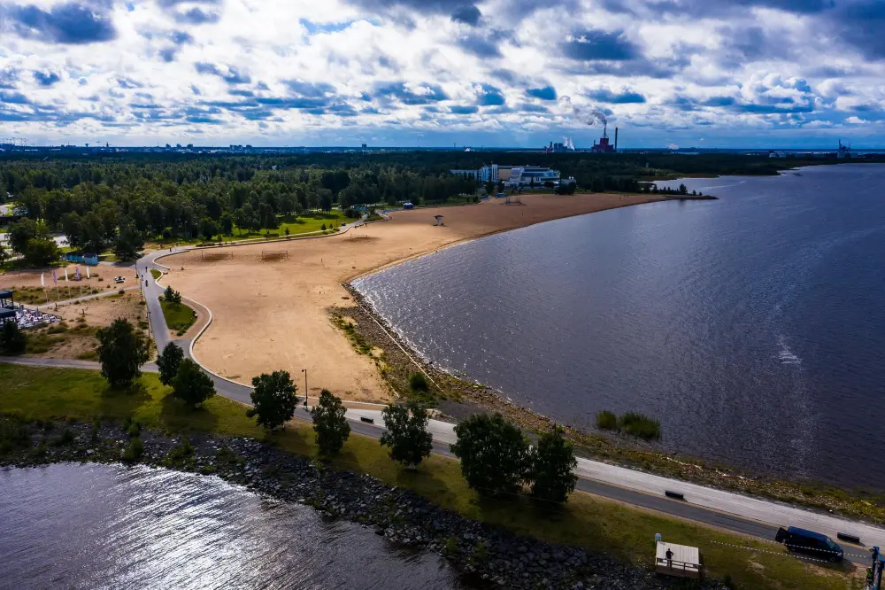 Trending European destinations displayed through an aerial view of Oulu’s coastline and sandy beach.