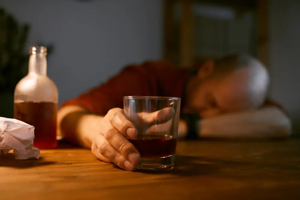 Traveler sitting outside airport terminal looking distressed after incident related to alcohol during trip