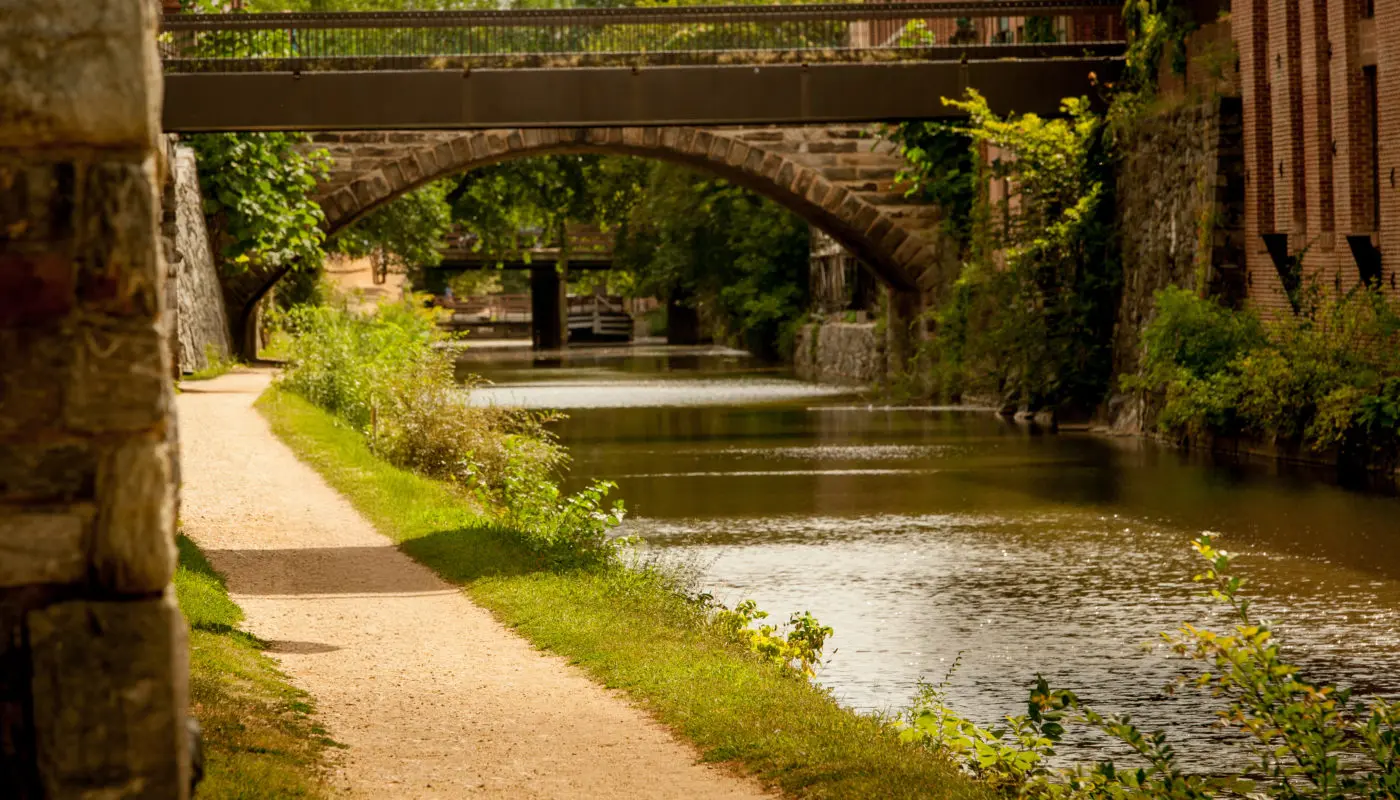 Historic lockhouse and campsite along the C&O Canal at sunset with towpath and canal locks visible
