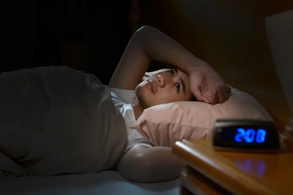 Traveler sleeping peacefully in a dark hotel room on the first night after arrival, adjusting to a new time zone