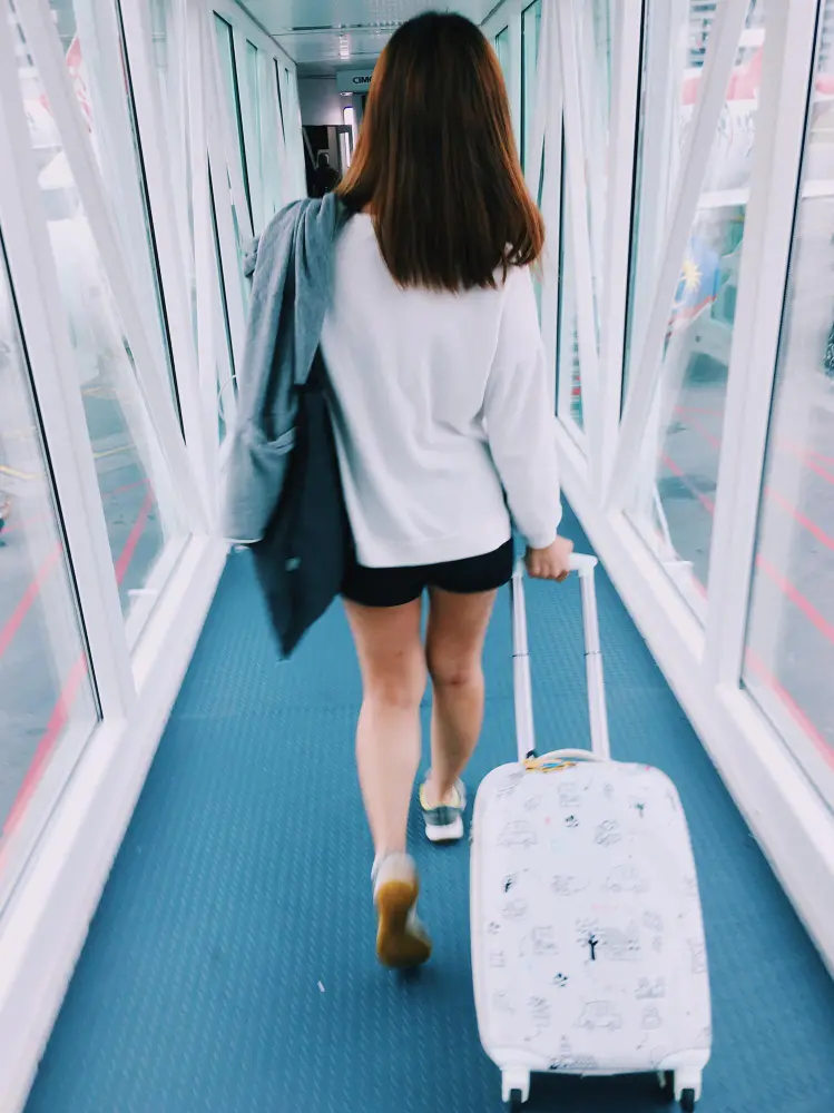 Airline passenger standing in the aisle and stretching during a long flight to stay active and reduce jet lag