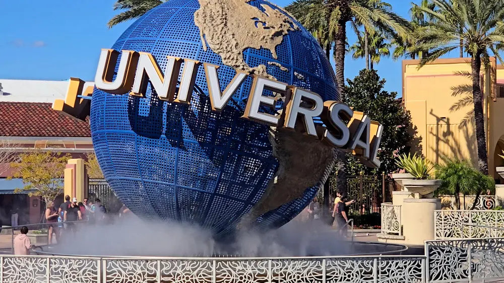 Family arriving early to plan a trip to Universal Studios on a budget in front of the park globe