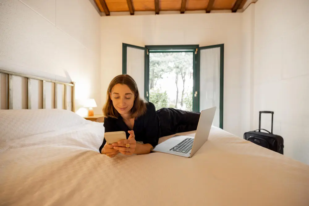 Traveler checking hotel room door lock and using a safe to secure valuables while traveling