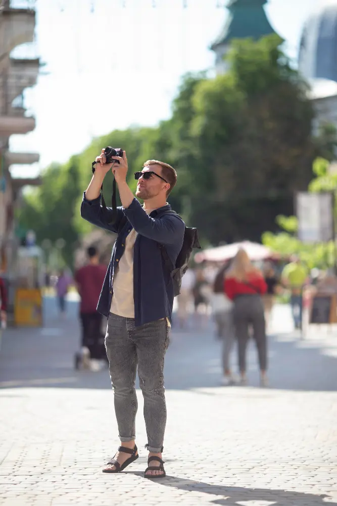 Tourist taking a photo of a local person without asking for permission in a busy street market