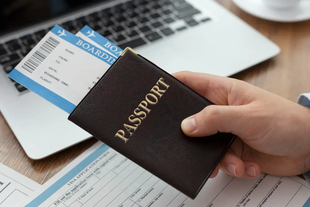 Organized travel documents including passport, visa papers, travel insurance, and ID cards arranged on desk for international trip