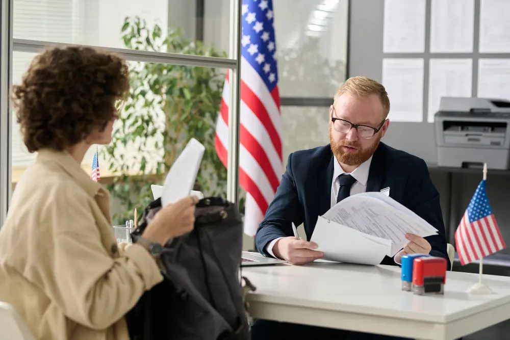 Traveler presenting documents at a foreign embassy counter to replace a lost passport