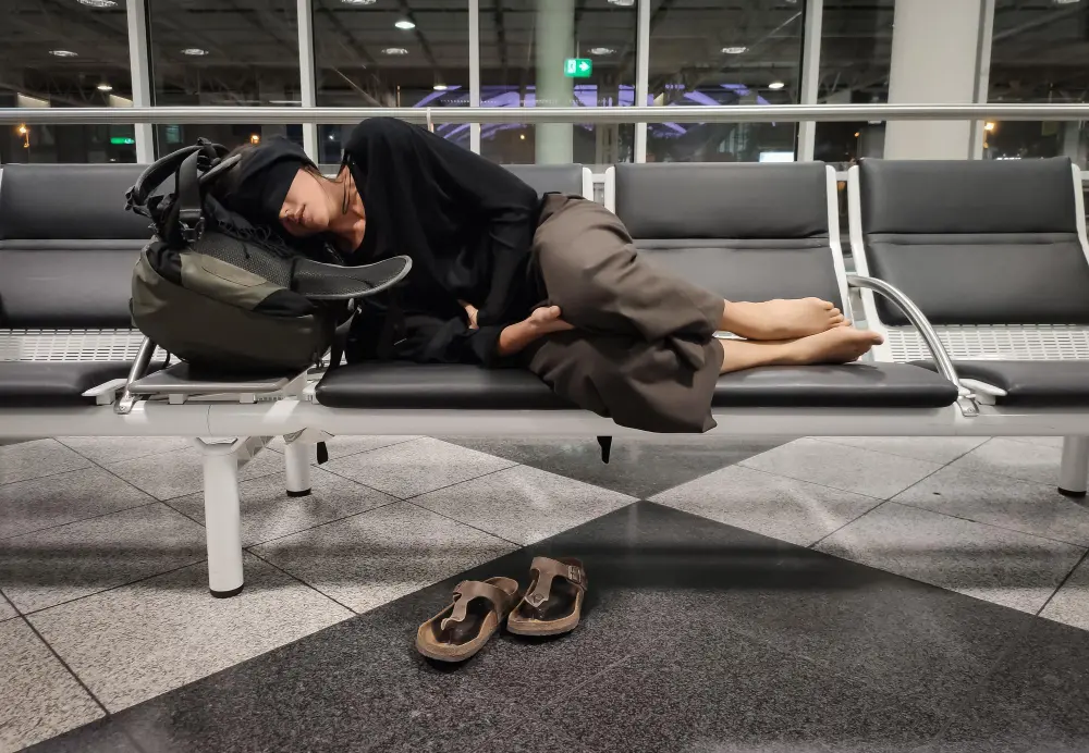 Traveler looking tired at an airport terminal, illustrating how jet lag affects the body after crossing multiple time zones