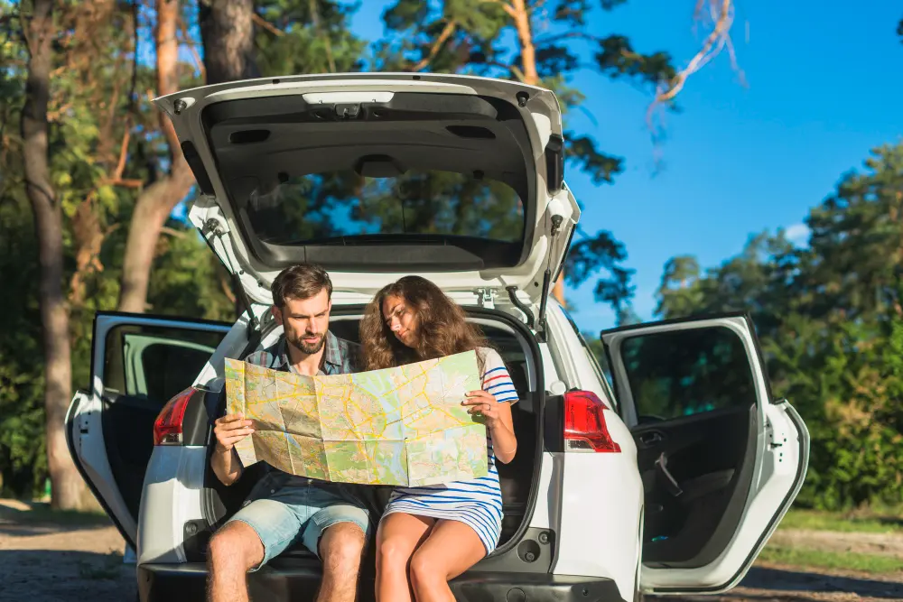 Traveler using a better route planner on smartphone with map displayed before road trip journey