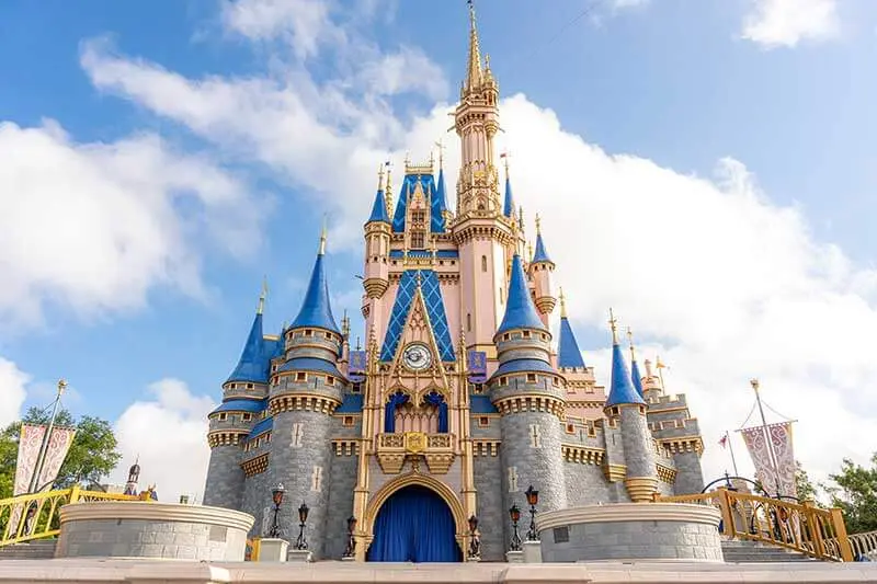 Visitors following their itinerary for Disney World exploring Magic Kingdom with Cinderella Castle in background at rope drop