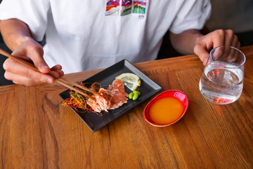 A delicious spread of Japanese ramen and sushi at a local restaurant, helping travelers estimate how much is to travel to japan.