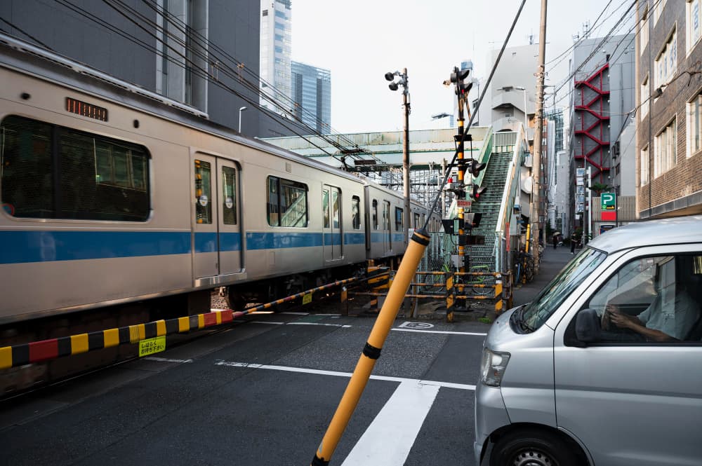A passenger tapping a smartphone at a Japanese subway gate, demonstrating how to travel in Japan using digital IC cards and local transit.