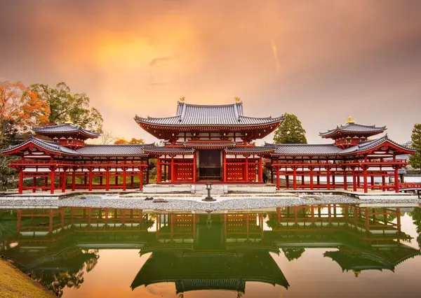 Travelers visiting a traditional red torii gate at a Shinto shrine while planning how much does it cost to travel japan.